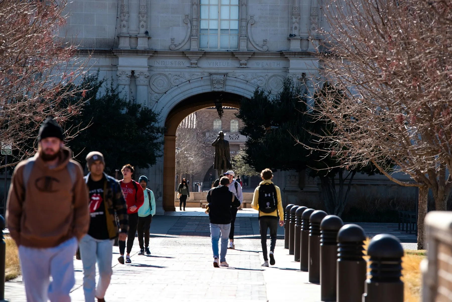 Students walking towards an archway on a university campus